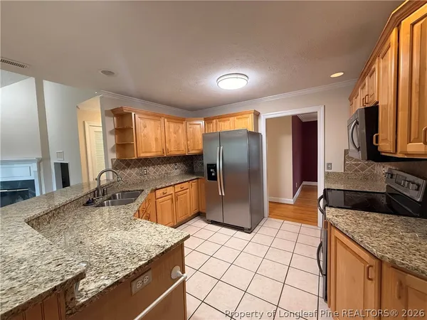 a kitchen with stainless steel appliances granite countertop a refrigerator and a sink