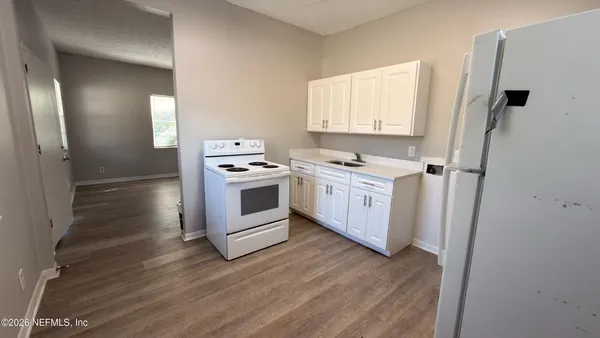 a kitchen with a stove top oven sink and refrigerator