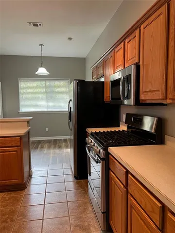 a kitchen with a stove a refrigerator and cabinets
