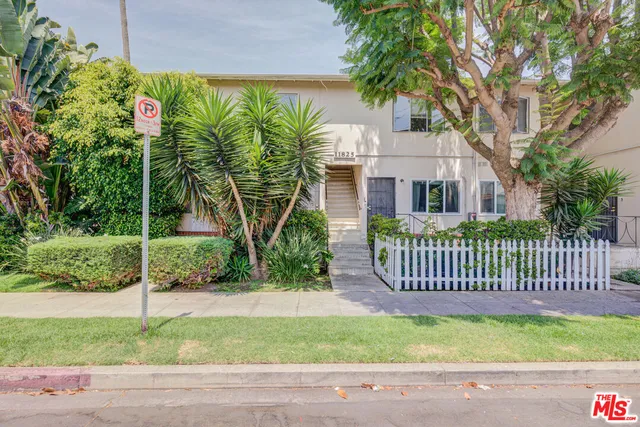 a front view of a house with a garden and plants