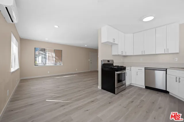 a kitchen with a stove top oven cabinets and wooden floor