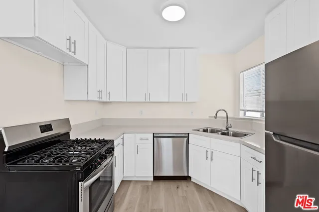 a kitchen with white cabinets sink and stove