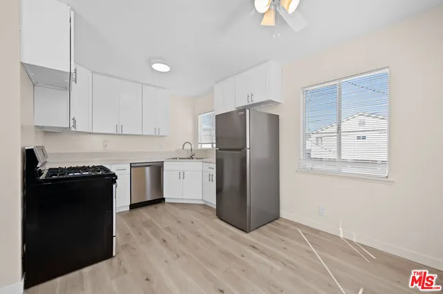 a kitchen with a refrigerator a stove a microwave and cabinets