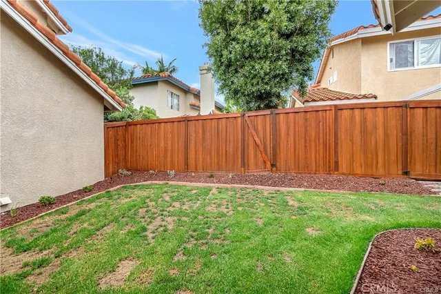a view of backyard with small cabin and wooden fence