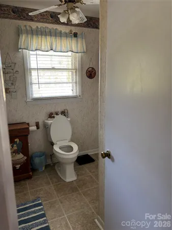 a bathroom with a toilet a sink and a window