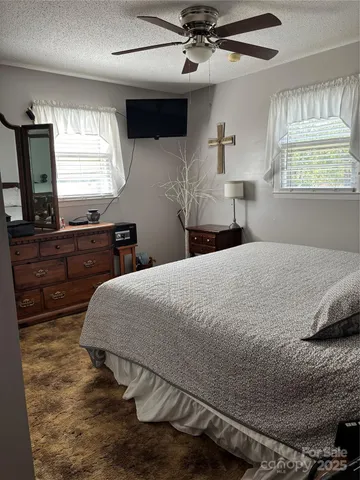a bedroom with a large bed and a flat tv screen on dresser