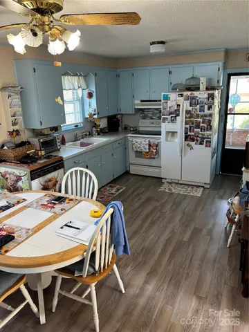 a kitchen with a dining table chairs and white appliances