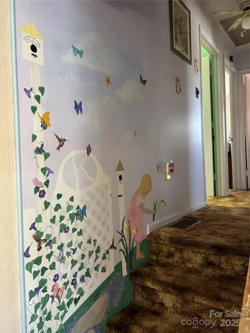 a bedroom with wooden floor and a chandelier