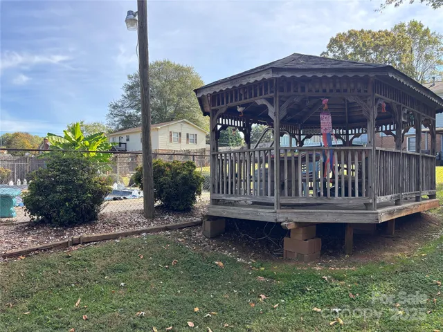 a view of a house with backyard wooden deck and a yard