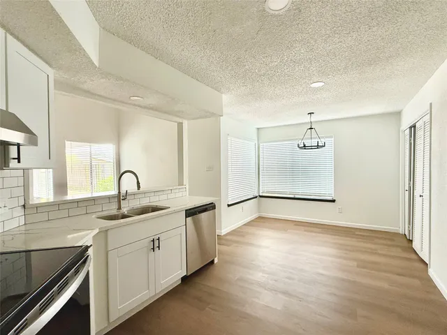 a kitchen with a sink cabinets stainless steel appliances and a window