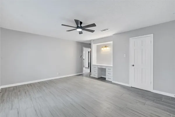 a view of empty room with wooden floor and ceiling fan