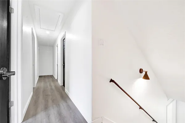 a view of a hallway with wooden floor