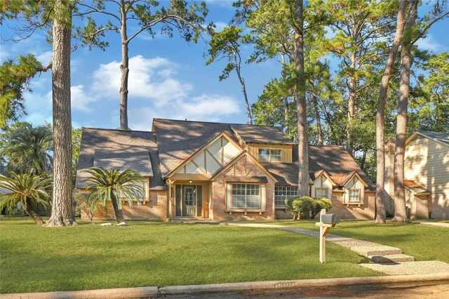 a view of a big house with a big yard and large trees