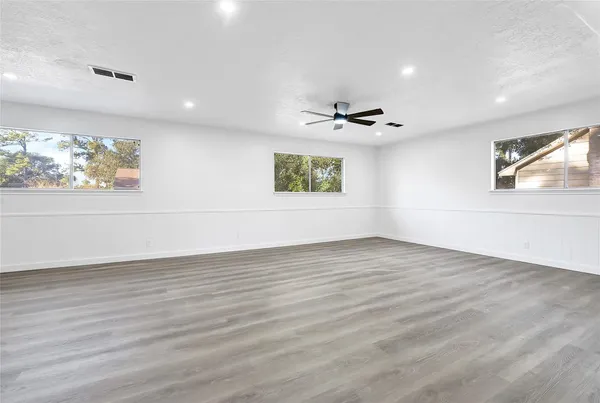 an empty room with wooden floor and window
