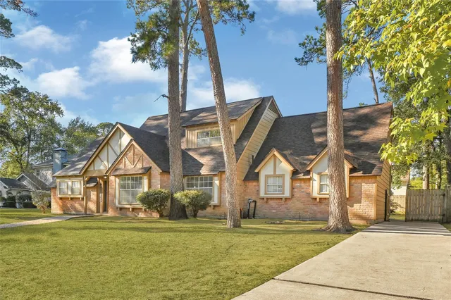 a front view of a house with a garden and trees
