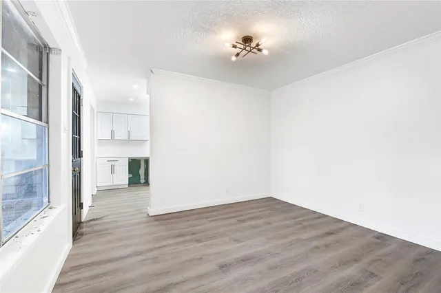 a view of empty room with wooden floor