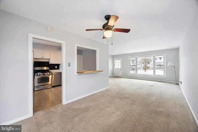 a view of a kitchen with a sink stove cabinets and empty room