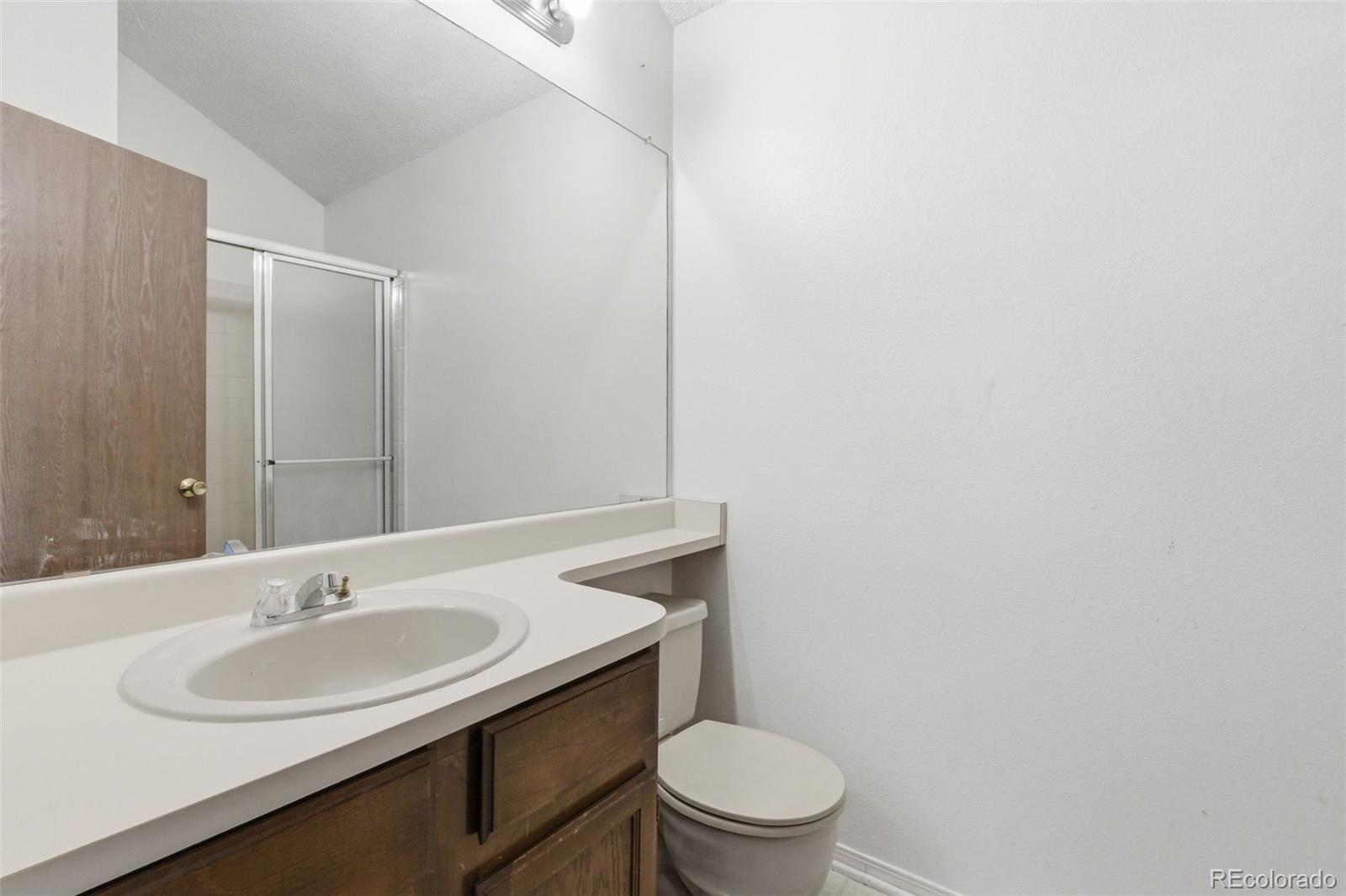 17335 East Rice Circle, Unit C Aurora, CO 80015 - Photo 11 of 14 a bathroom with a sink toilet and a mirror