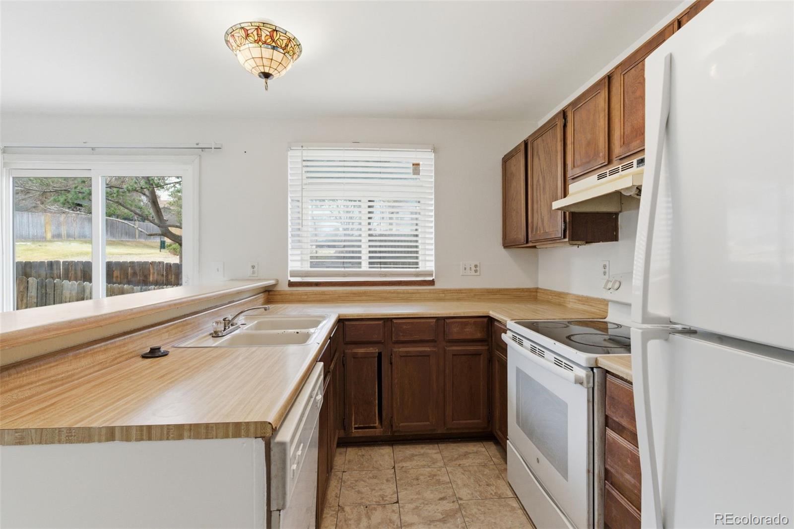17335 East Rice Circle, Unit C Aurora, CO 80015 - Photo 5 of 14 a kitchen with a sink stove and microwave
