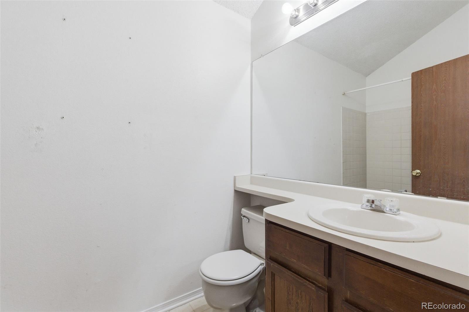 17335 East Rice Circle, Unit C Aurora, CO 80015 - Photo 9 of 14 a bathroom with a sink a toilet and a mirror