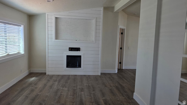 1450 North Dixie Downs Road, Unit 51 St. George, UT 84770 - Photo 7 of 25 Living area featuring wood-finish flooring, a contemporary electric fireplace with shiplap surround, and a built-in media niche