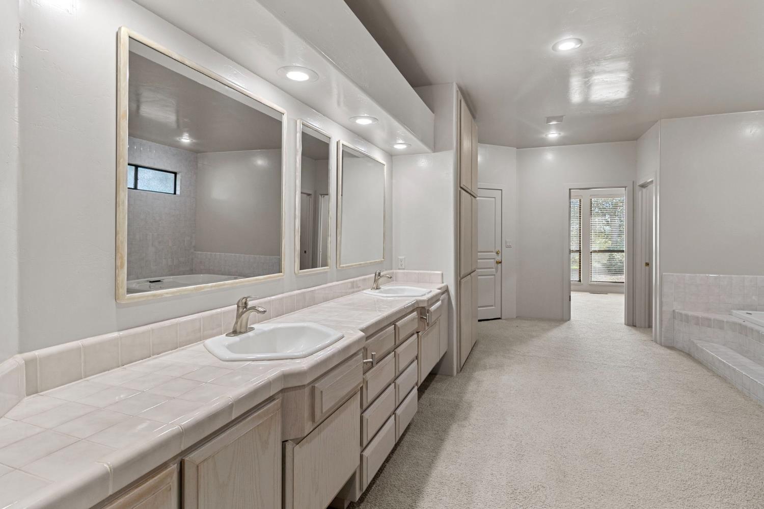 5724 Parker Road Modesto, CA 95357 - Photo 30 of 69 a bathroom with a sink double vanity granite tub shower and a mirror