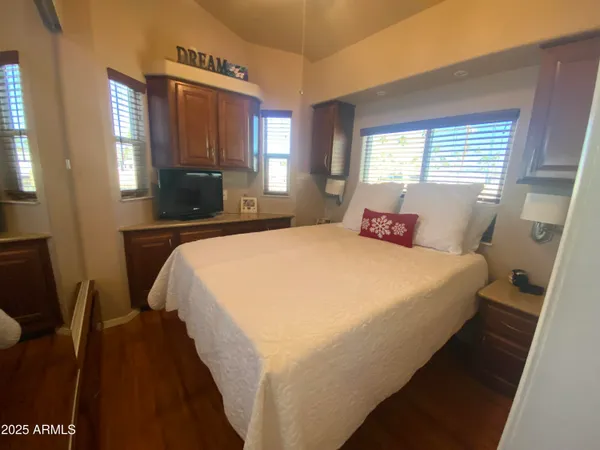 a bedroom with a bed a mirror on dresser and a window