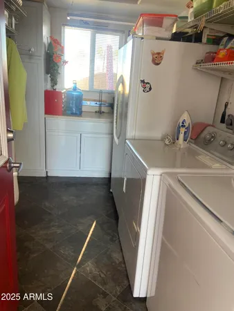 a utility room with cabinets washer and dryer