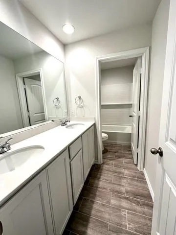 a bathroom with a double vanity sink and a mirror