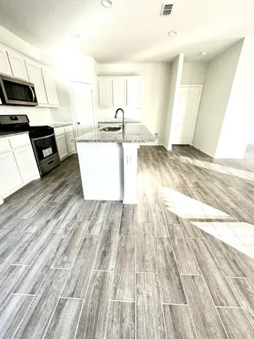 a view of kitchen with wooden floor and electronic appliances