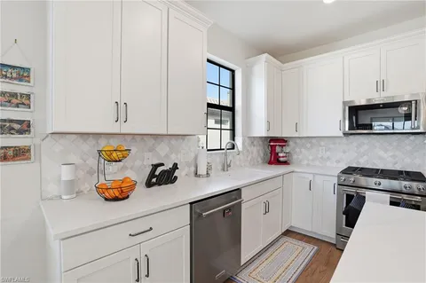 a kitchen with stainless steel appliances granite countertop a sink a stove and cabinets