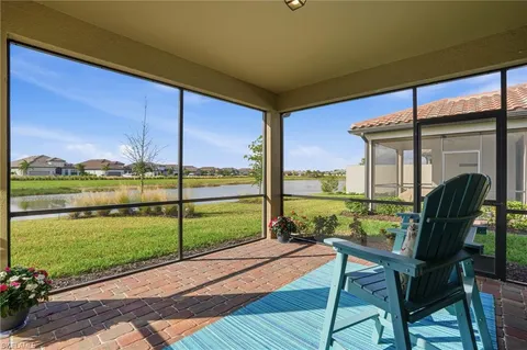 a view of a chairs and table in patio with a lake view