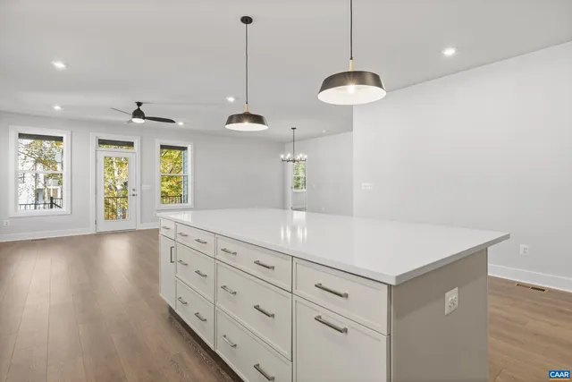 a view of a center island wooden floor and windows