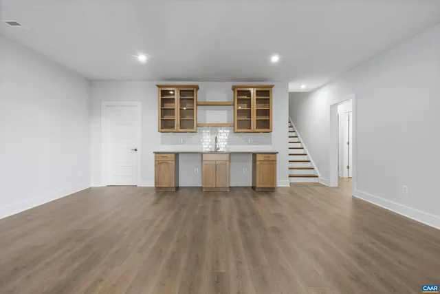 a view of a kitchen with wooden floor and stairs