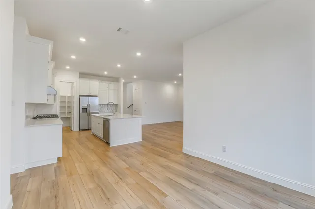 a view of kitchen with kitchen island white cabinets and stainless steel appliances