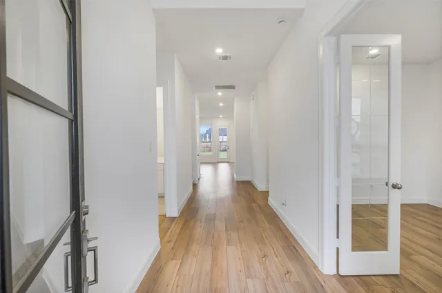 a view of a hallway with wooden floor and staircase