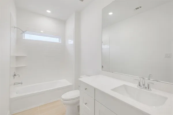 a bathroom with a bathtub shower sink vanity and toilet