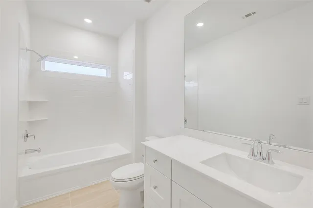 a bathroom with a bathtub shower sink vanity and toilet