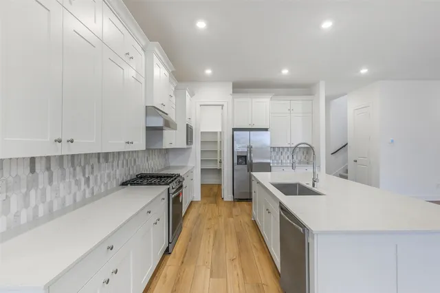 a kitchen with refrigerator a sink and cabinets