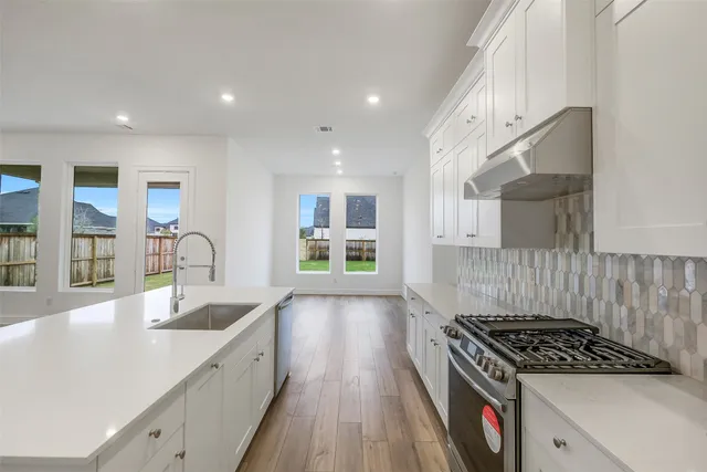 a kitchen with granite countertop a stove and a sink