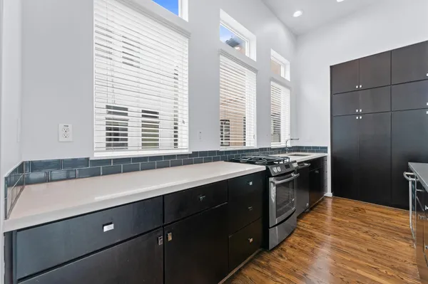 a large kitchen with stainless steel appliances a large counter top a stove and a refrigerator