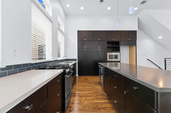 a kitchen with counter top space and wooden floor