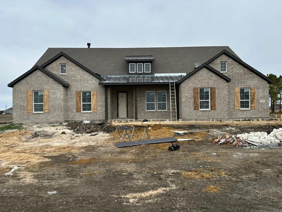 View of front of house featuring a porch and brick siding