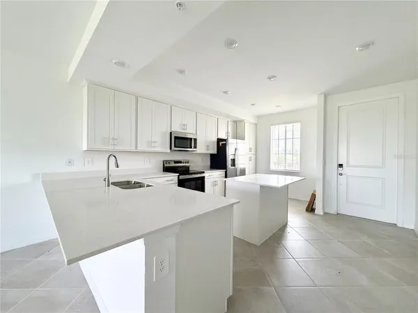 a kitchen with a sink a counter top space cabinets and stainless steel appliances