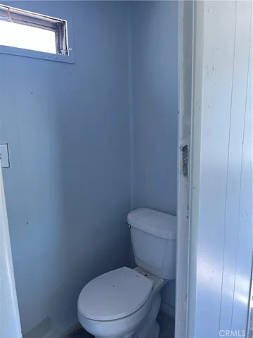 a white toilet sitting next to a shower