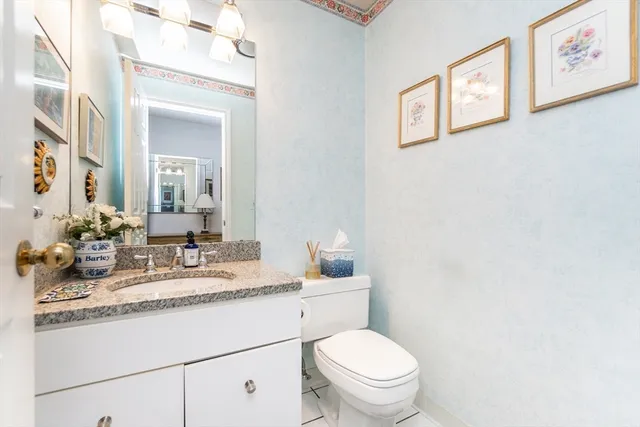 a bathroom with a granite countertop toilet sink and a mirror