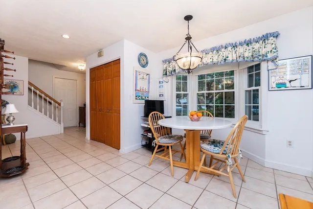 a dining room with furniture a chandelier and kitchen view