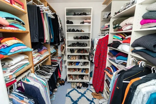a view of walk in closet with clothes and shoes