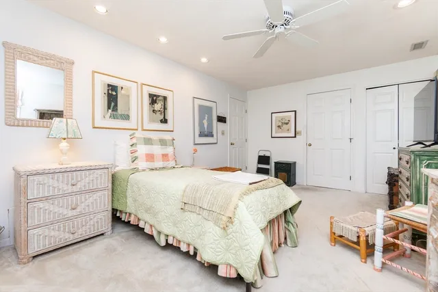 a spacious bedroom with a bed a table and chair