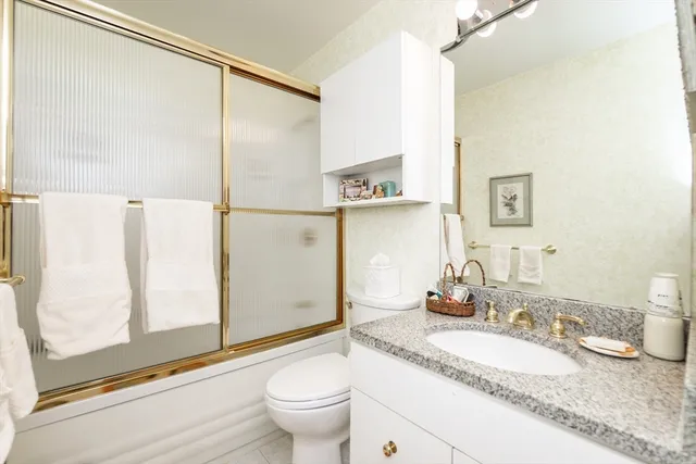 a bathroom with a granite countertop sink mirror and a bathtub